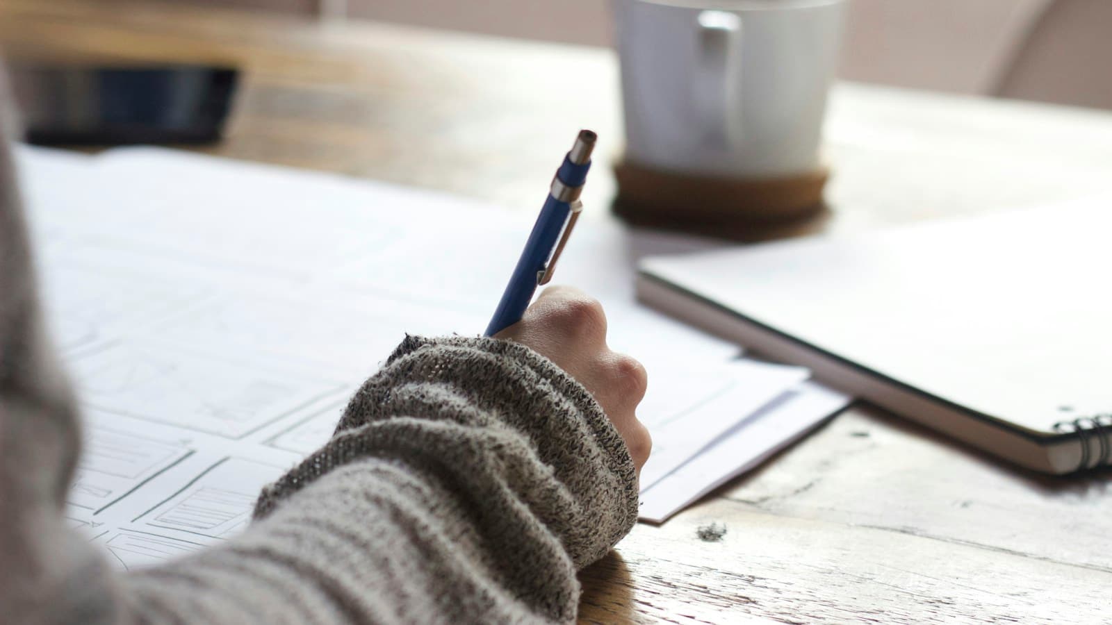 Landscape image of research notes, a ruler, and a notebook organized on a bright desk for planning a study method.